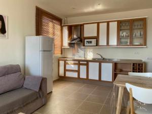 una cucina con divano, frigorifero e tavolo di Ed Senses Apartamento Happiness a Tarifa