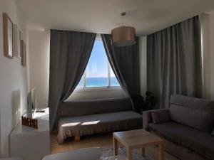 sala de estar con sofá y ventana grande en Ed Senses Apartamento Happiness, en Tarifa