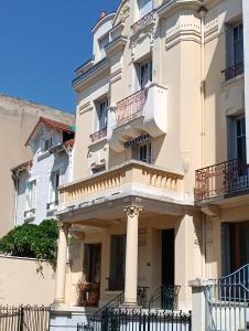 een groot wit gebouw met zuilen en balkons bij Havre de paix Les pélicans in Vichy