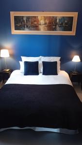 a blue bedroom with a large bed with two blue pillows at Eden 122 in Albi