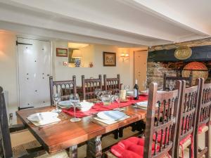 a dining room with a long wooden table and chairs at Milton Cottage, Nr Thurlestone - a delightful thatched cottage close to the beach in Thurlestone