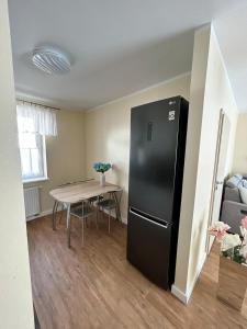 a black refrigerator in a room with a table at Lazur Apartamenty in Świnoujście