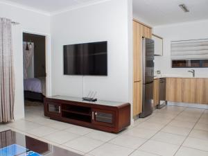 a living room with a flat screen tv on a wall at 1254 The Blyde Crystal Clear 3 Bedroom Garden Apartment in Pretoria