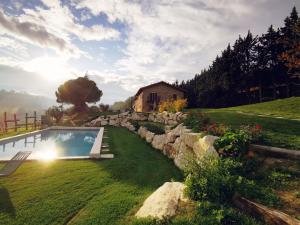 a garden with a swimming pool and a stone wall at GaeLeon Campofilone in Campofilone