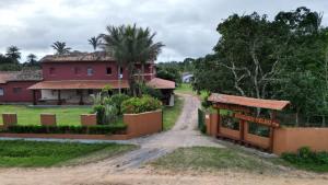 polna droga prowadząca do czerwonego domu w obiekcie HOTEL FAZENDA Engenho Velho w mieście Ubajara
