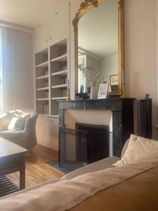 uma sala de estar com lareira e espelho em Maison classée 3 étoiles à Vouvray Loire Valley em Vouvray