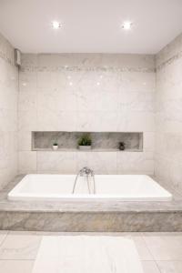 - białą wannę w białej łazience w obiekcie Entire Luxury Sliema Townhouse Steps from Beach w mieście Sliema