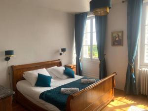een slaapkamer met een bed met blauwe en witte kussens bij Maison classée 3 étoiles à Vouvray Loire Valley in Vouvray