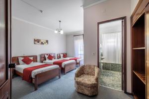 una habitación de hotel con 2 camas y una silla en Hotel Colmeia en Monte Real