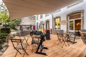 a patio with tables and chairs on a wooden deck at Chateau Melay in Melay