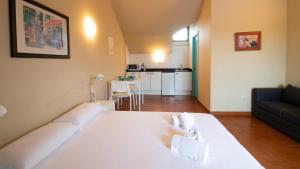 a bedroom with a white bed and a living room at Resort Camping Santillana del Mar in Santillana del Mar