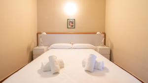 1 dormitorio con 1 cama blanca y 2 toallas blancas en Resort Camping Santillana del Mar, en Santillana del Mar