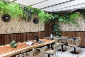 a restaurant with a table and chairs with a laptop on it at Hotel Khla Nice in Nice