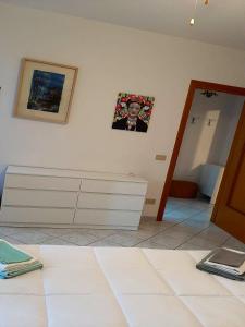 une chambre avec une commode blanche et une photo sur le mur dans l'établissement 2 bedrooms apartement with sea view furnished terrace and wifi at Olbia 5 km away from the beach, à Olbia