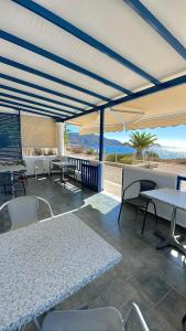 a patio with tables and chairs under a canopy at Ardani Bay Studios in Amoopi