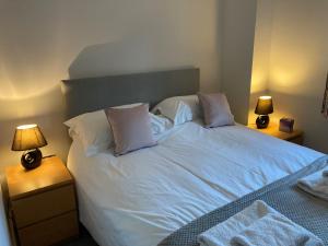 a bedroom with a bed with white sheets and pillows at Dartmoor View one bedroom Apartment Dog Friendly Close To Town FREE PARKING in Totnes