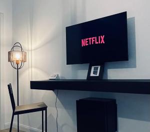 a television on a desk with a chair and a lamp at Carducci 83 in Pescara