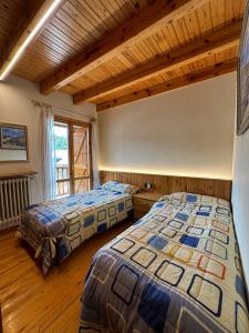 Dos camas en una habitación con suelo de madera. en Casa Margarita, en Sesué