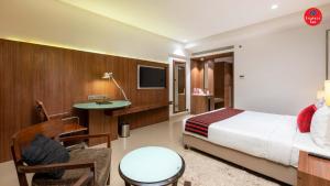 a hotel room with a bed and a desk and a tv at Express Inn The Business Luxury Hotel in Nashik