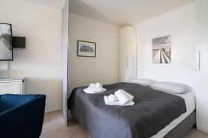 1 dormitorio con 1 cama con toallas en H3-53-Hanseat-Aussenschwimmbad, en Scharbeutz