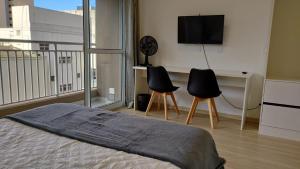 Un dormitorio con una cama y dos sillas y un televisor. en Studio 27m2 Wifi Liberdade Proximo Metro Restaurante Hospital, en São Paulo 19 fotos más