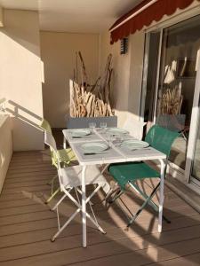 einen weißen Tisch und zwei Stühle auf einer Veranda in der Unterkunft Appart Hypercentre Biarritz - PKG / WIFI / 4-6 Personnes in Biarritz