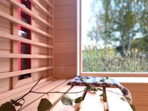 uma mesa sentada num alpendre ao lado de uma janela em Lunette Lodge am See mit Sauna für 10 Gäste em Brzozie
