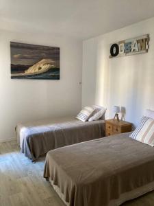 ein Schlafzimmer mit 2 Betten und einem Wandgemälde in der Unterkunft Appart Hypercentre Biarritz - PKG / WIFI / 4-6 Personnes in Biarritz