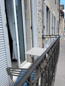 uma mesa na varanda de um edifício em Appartement T4 70m2 - meublé - centre ville - proche Thermes em Lons-le-Saunier