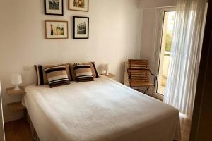 ein Schlafzimmer mit einem großen Bett und einem Fenster in der Unterkunft Appart Hypercentre Biarritz - PKG / WIFI / 4-6 Personnes in Biarritz
