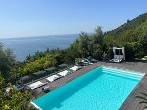 a swimming pool with chairs and a view of the ocean at Luxurious studio suite near Monaco with sea view in Éze