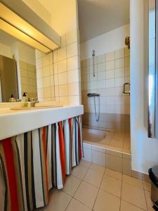 ein Badezimmer mit einer Dusche, einem Waschbecken und einer Badewanne in der Unterkunft Appart Hypercentre Biarritz - PKG / WIFI / 4-6 Personnes in Biarritz