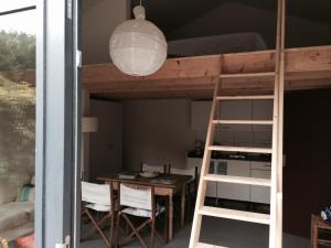 a room with a bunk bed and a table and a desk at Almost At The Beach in Wijk aan Zee