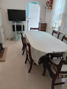 una mesa con un mantel blanco encima en King-size room in house en Londres