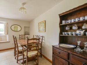 a dining room with a wooden table and chairs at Riverbank in Axminster