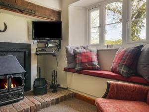 a living room with a couch and a fireplace at Riverbank in Axminster