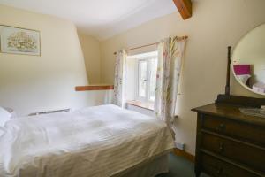 a bedroom with a bed and a mirror and a dresser at Riverbank in Axminster