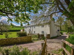 an old white house with a fence in front of it at Riverbank in Axminster