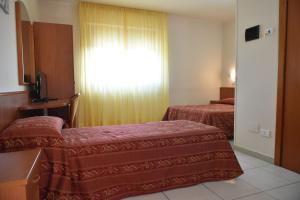 A bed or beds in a room at Hotel e Appartamenti La Solaria