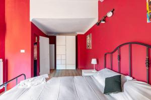 ボローニャにあるCorte de’ Galluzzi My Home For Youの赤い壁のベッドルーム1室(大型ベッド1台付)