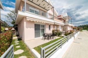 ein Haus mit einer Terrasse, einem Tisch und Stühlen in der Unterkunft Dionysos Residential Complex in Ofrynio