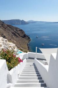 a staircase leading down to the water with flowers at Canaves Ena - Small Luxury Hotels of the World in Oia