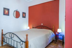 a bedroom with a bed and a red wall at Sunny Apartment in Athens