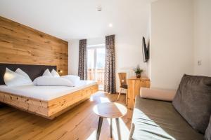 a living room with a bed and a couch at Hotel Antholzerhof in Anterselva di Mezzo