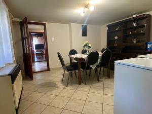 a kitchen and dining room with a table and chairs at Emese Vendégház in Tiszafüred