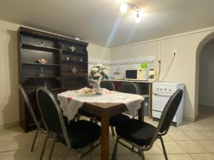 a kitchen with a table with chairs and a table and a kitchen with a kitchen at Emese Vendégház in Tiszafüred +18 photos