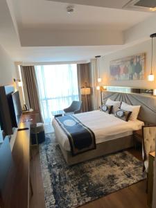 a hotel room with a large bed and a television at GRAND HAMİT By Karadayı Airport Hotel in Arnavutköy