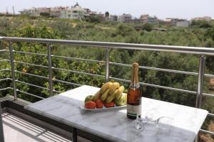 a bottle of wine and a plate of fruit on a table at Luana Monte Apartments in Amoudara Herakliou