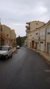 ein Auto, das an der Seite einer Straße mit Gebäuden parkt in der Unterkunft la perle de bougie in Bejaïa