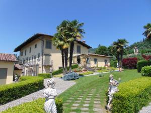 a garden with statues in front of a house at Galleria Imperiale Suites in Sarnico
